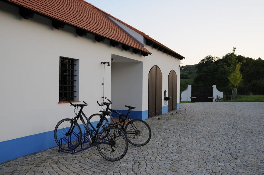 Bílá garáž s obloukovými vraty a dvě kola na stojanu
